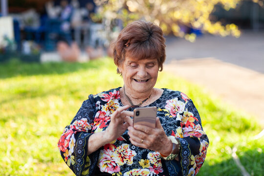 senior woman using mobile phone outside in garden