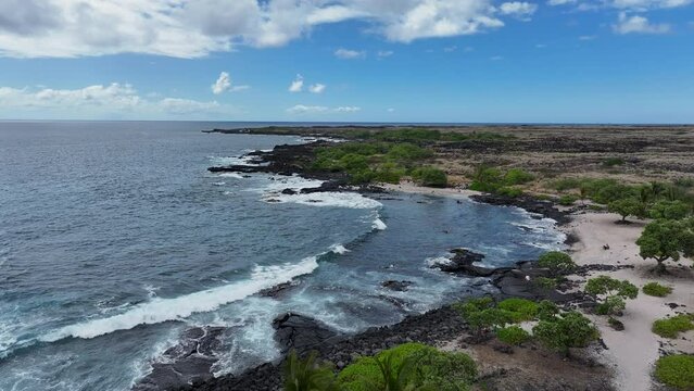 Aerial beautiful beach cove surf tropical seascape. Blue Pacific ocean water. Snorkel and scuba dive vacation destination. Black volcanic lava rock. Recreation and relaxation. Tropical landscape.