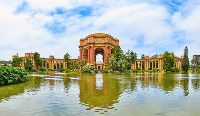 Fototapeta na wymiar Panorama from across lake water with Palace of Fine Arts under cloudy blue sky