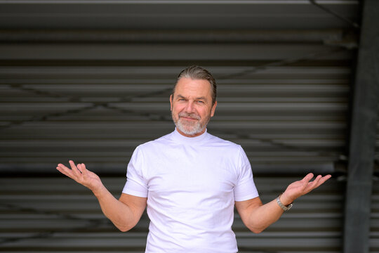 Man has his arms spread wide and looks questioningly