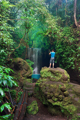 Travel people enjoy beautiful view tropical waterfall in rainforest jungle on nature background - obrazy, fototapety, plakaty