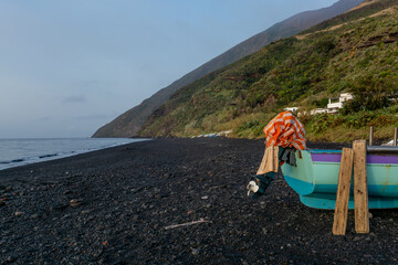 Fototapeta na wymiar fishing boat in volcanic landscape on the island of Stromboli