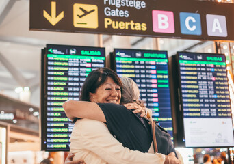 Couple of women hugging and goodbye in airport area for arriving or departing trip, feeling for long distance relationship. Two mature women embracing each other affectionately before leaving