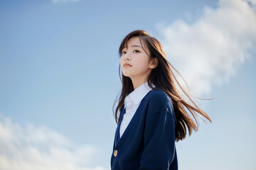 青空をバックに悲しげに微笑む女子高生