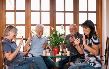 Video call concept. Four Happy  Senior Caucasian People Sitting at Table Enjoying Coffee Cup and Using Phones Technology for Online Webcam Communication. Retired Lifestyles Conceps