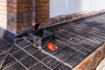 Iron fittings on a wooden formwork with laid pipes are the basis for pouring the foundation of the...
