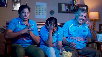 Indian family got sad due to loss of cricket match while watching on tv or television at home - concept of competition, championship and disappointment audience or fans. - Powered by Adobe