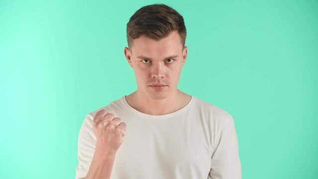 Young man in a bad mood and angry. Shows negative emotions, unfriendliness and hostility. Readiness for self-defense or attack. The guy demonstrates courage and power to intimidate the enemy.