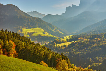 Amazing autumn scenery in Santa Maddalena village with church, colorful trees and meadows under...