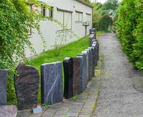 Neue Grabsteine stehen in einer Reihe zum Eingang eines Steinmetzes  zum Verkauf