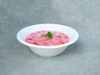 fruit soup and jelly served in bowls. pink soup. watermelon and melon ice on gray background. fresh and delicious