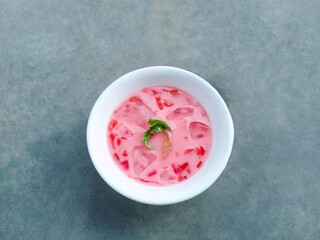 fruit soup and jelly served in bowls. pink soup. watermelon and melon ice on gray background. fresh and delicious