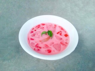 fruit soup and jelly served in bowls. pink soup. watermelon and melon ice on gray background. fresh and delicious. Close up