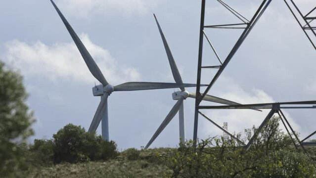 Three wind turbines framed by metal structures.