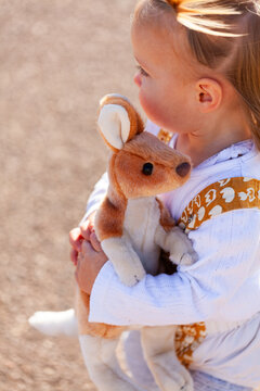 little Aussie girl with kangaroo plush toy outside