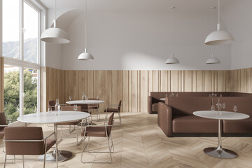 Elegant cafe interior with dinner table and brown leather sofa, panoramic window