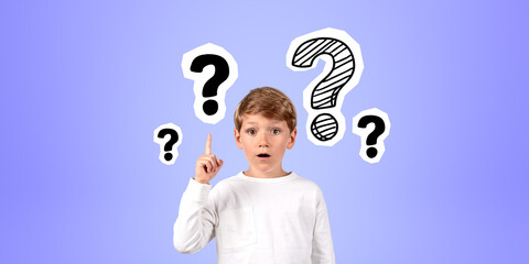 Impressed boy with finger point up at question marks on blue background - obrazy, fototapety, plakaty