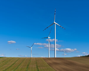 Photo of wind turbines, an eco-friendly energy source, against a clear blue sky near Vienna. A symbol of sustainable energy and environmental progress.