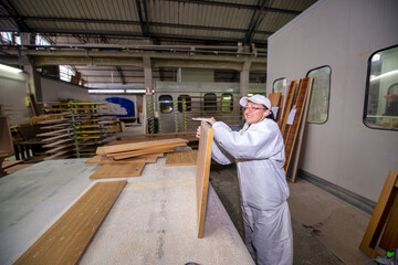 Fototapeta premium A female worker prepares a sheet of wood for subsequent painting