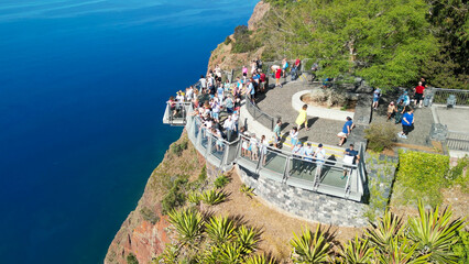 Tourists enjoy the viewpoint at Cabo Girao, along the Madeira coastline, Portugal. Aerial view from...