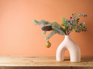 Christmas background  with pine tree branches in modern vase on wooden table