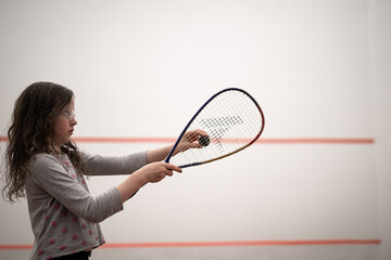 young caucasian girl racquet squash holiding ball game court win compete play strategy fun child