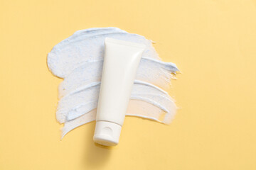 Tube of facial cleanser without label or body cream tube with open cap and product squeezed cream...