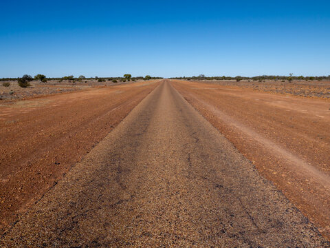 Straight single laned sealed road disappearing in the distance