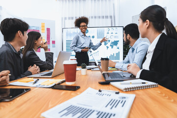 Young african businesswoman presenting data analysis dashboard on TV screen in modern meeting. Business presentation with group of business people in conference room. Concord