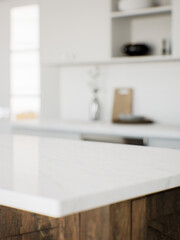 Focus on the marble countertop against the backdrop of kitchen appliances and utensils.