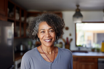Portrait of elegant confident senior lady with gray hair and beautiful smile in her kitchen.