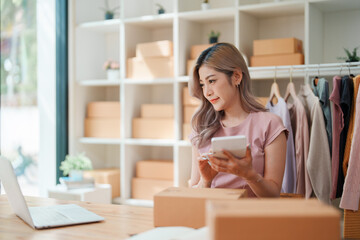 Small business, online business owner, young woman is using profit calculator and checking inventory