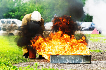 A fire protection officer extinguishes the ignition of fuel in a special container with a portable...