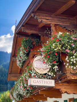 Going, Austria - October 10, 2021: Sign of "Gasthof Wilder Kaiser" in Going, Austria on a house, a famous TV backdrop against blue sky
