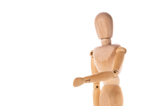 A wooden mannequin standing on a white surface. This versatile image can be used in various contexts. - Powered by Adobe