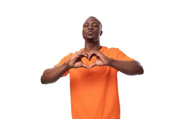 young nice kind american man dressed in an orange t-shirt on a white background with copy space