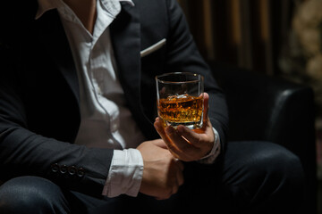 Businessman wearing a suit whiskey glass of liquor.