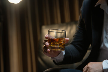 Businessman wearing a suit whiskey glass of liquor.