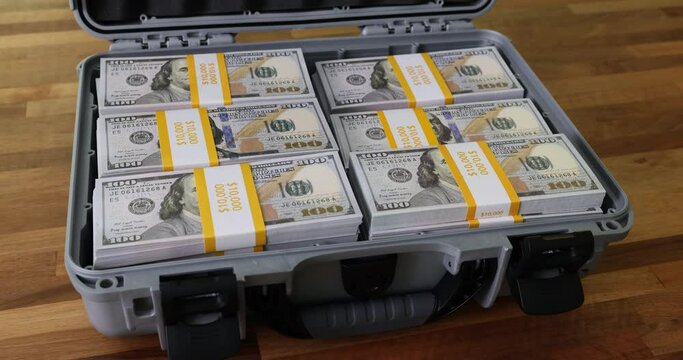 Closeup of briefcase full of stacks of dollar bills and cash. Concept of business success or crime and bribes