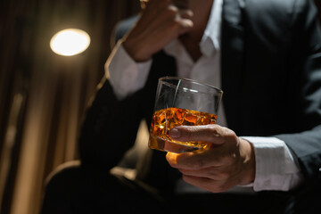 Businessman wearing a suit whiskey glass of liquor.