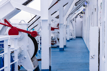 Photo of the exterior corridor of a large ship with all its machinery.