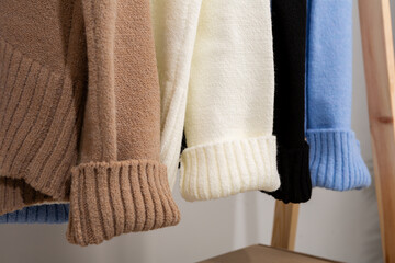 Wollen warm knitted sweaters close up on a hanger women's clothing