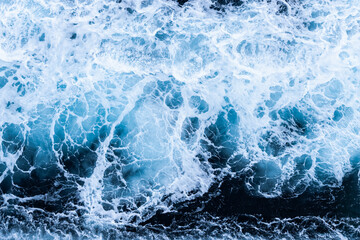 High angle view of a blue abstract background with sea foam design. Drone pointing view