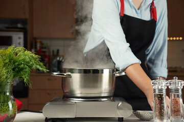 Steel cooking pan on electric hob with boiling water