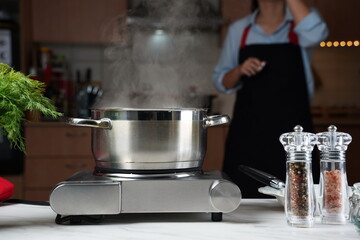 Steel cooking pan on electric hob with boiling water