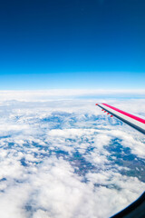 View from the window of the aircraft on the wing. Aairplane window with clouds view. Travel by airplane concept.  