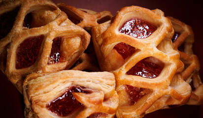 Puff pastry pastry with lingonberry jam on a dark red background. Cookies with lingonberry jam.
