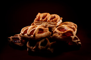 Puff pastry pastry with lingonberry jam on a dark red background. Cookies with lingonberry jam.