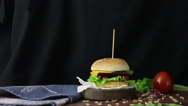 Big hot tasty hamburger close up. Making beef burger. Junk food concept. Homemade bbq sandwich. Cook perfect lunch. Stop motion animation. Fast meal diet. Yum grilled american dinner. Black background