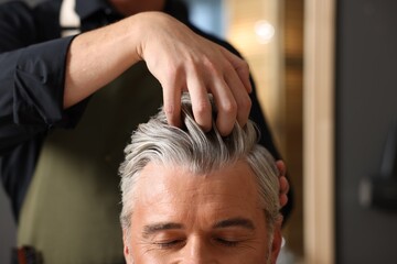 Hair styling. Professional hairdresser working with client in barbershop, closeup